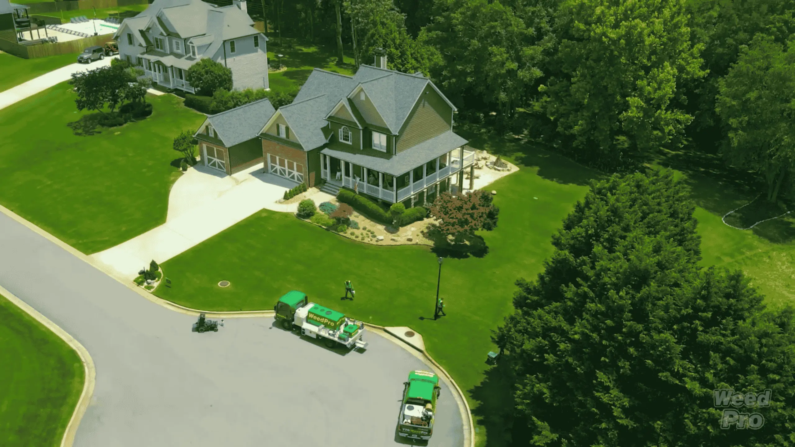 Aerial view of WeedPro service trucks and crews treating lawns in a suburban Atlanta, GA neighborhood.