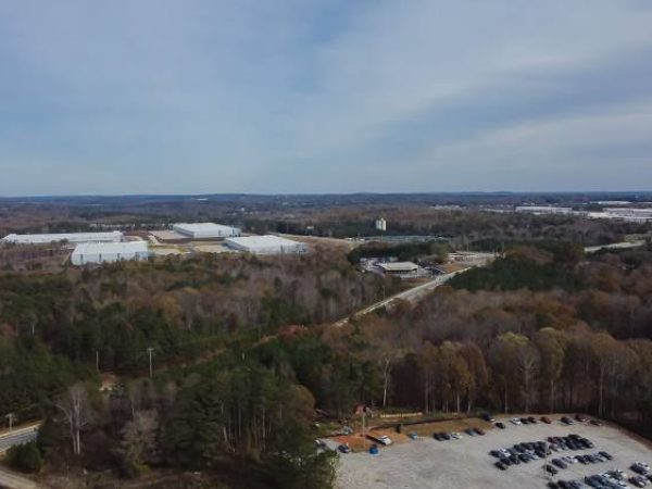 Aerial view of Buford, GA, showcasing a mix of wooded areas and commercial buildings, emphasizing the local landscape and service area for Weed Pro Lawn Care.