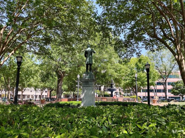 Statue surrounded by lush greenery in a park setting, with trees and lampposts, representing Cobb County, GA, and enhancing the community's outdoor aesthetic.