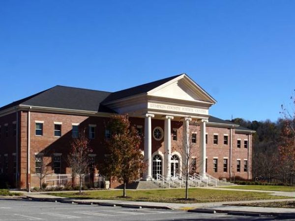 Lumpkin County Justice Center building with brick architecture, surrounded by trees and clear blue sky, representing local government services in Dahlonega, GA.