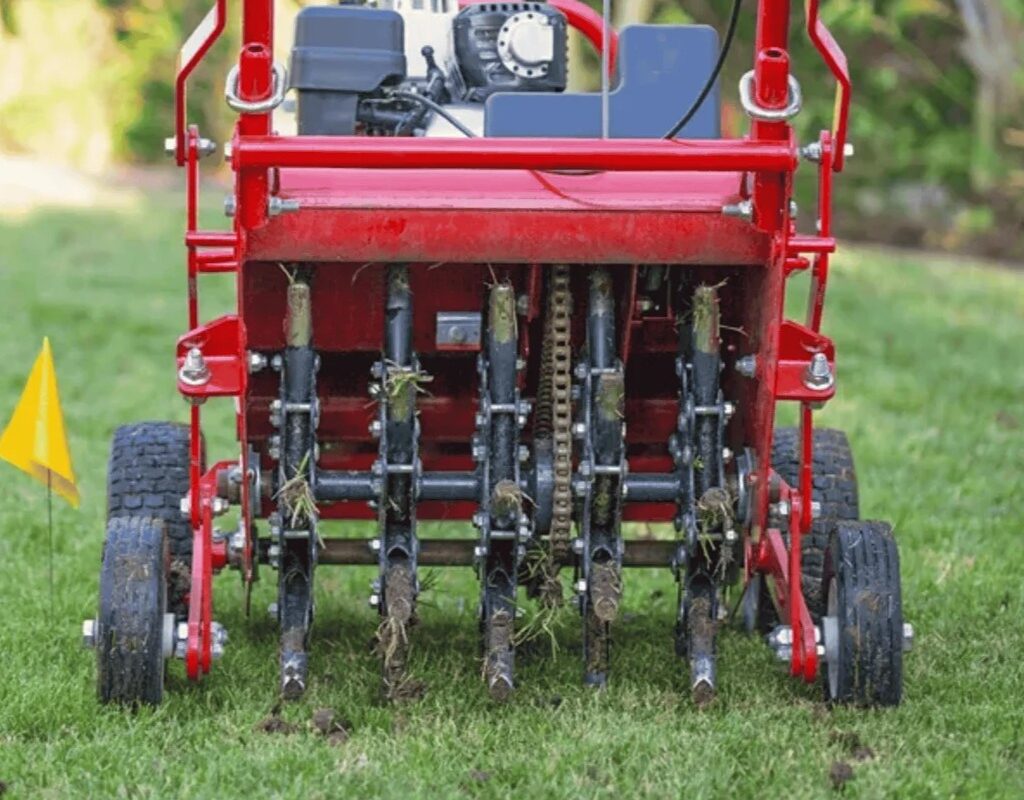 Lawn core aeration machine on grass, highlighting soil plugs being extracted for healthier lawn maintenance and pest control in Grayson, GA.