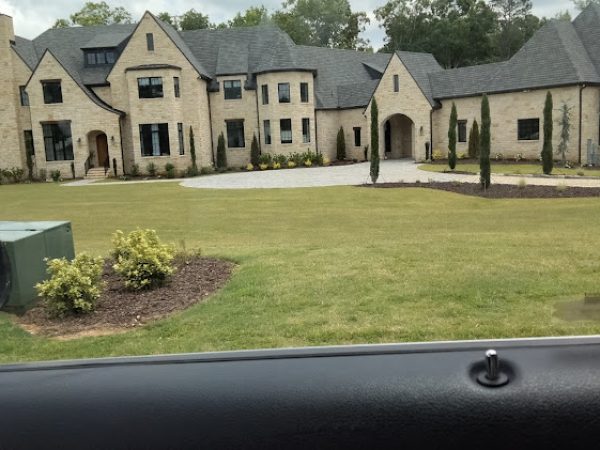 Elegant residential property with manicured lawn, showcasing vibrant greenery and landscaped flower beds, highlighting Weed Pro's lawn care services in Fulton County, GA.